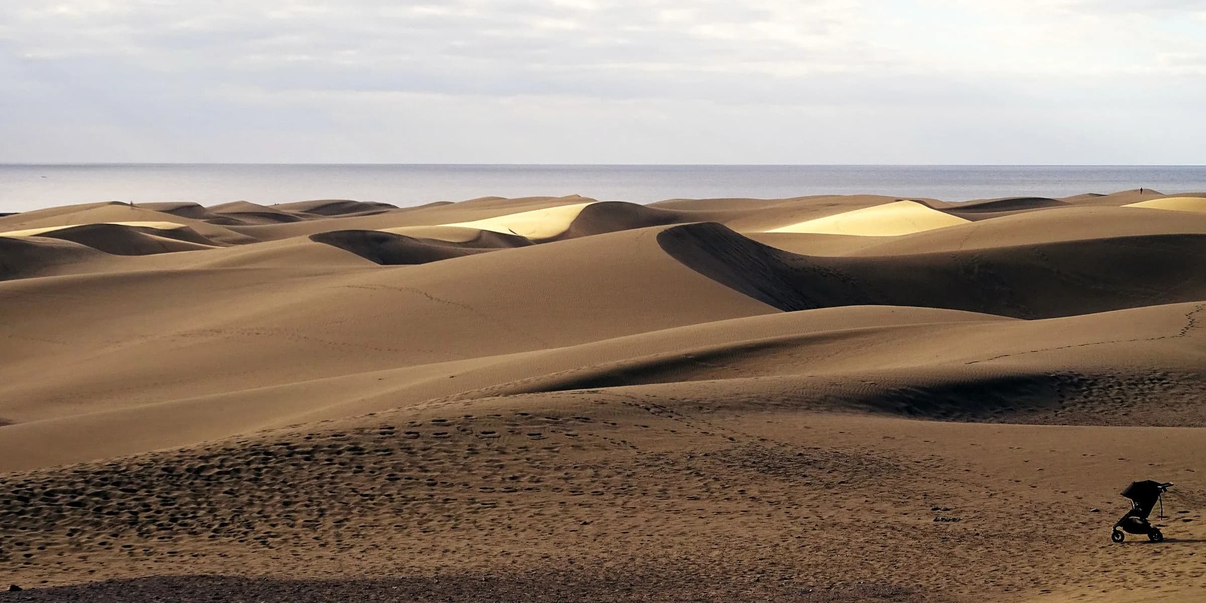 Maspalomas sand dunes beneath a bright sky beside the sea